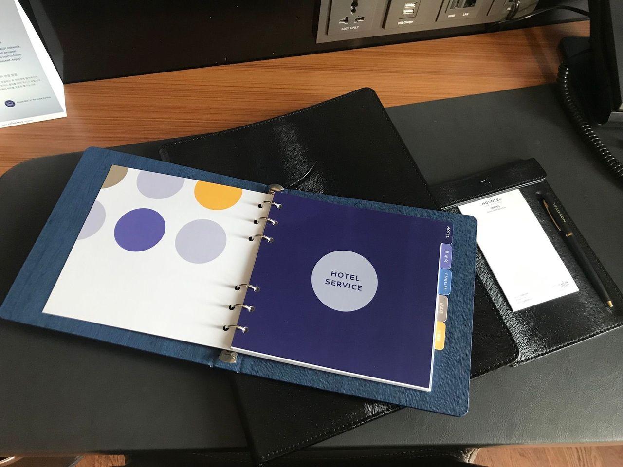 Close-up view of the hotel service guidebook and stationary at Dongdaemun Novotel Ambassador Hotel.